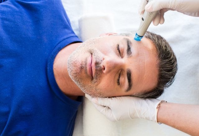 Male patient model getting face treatment