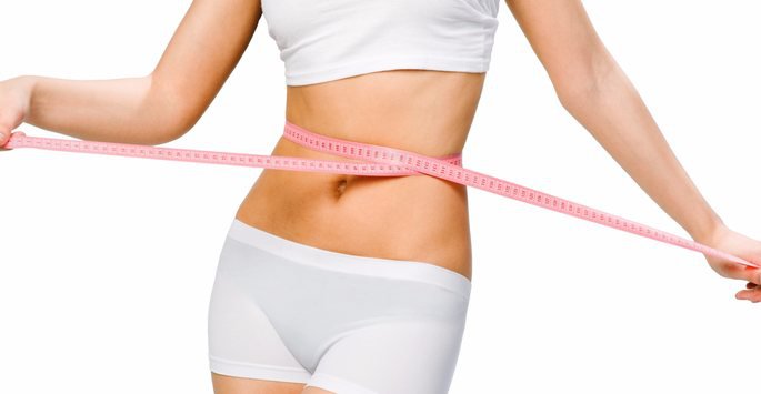 Slim female patient model using measuring tape around waist