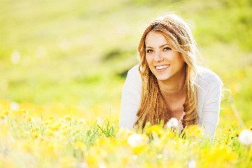 Beautiful female patient model laying in a field full of flowers